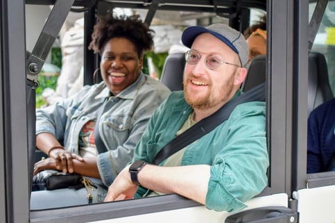 2 circuit riders smile looking out of a vehicle
