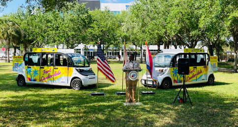 Fort Lauderdale Commissioner standing at a podium in front of Fort Lauderdale Circuit cars
