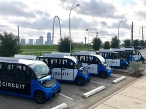 Circuit cars lined up with dallas skyline in background