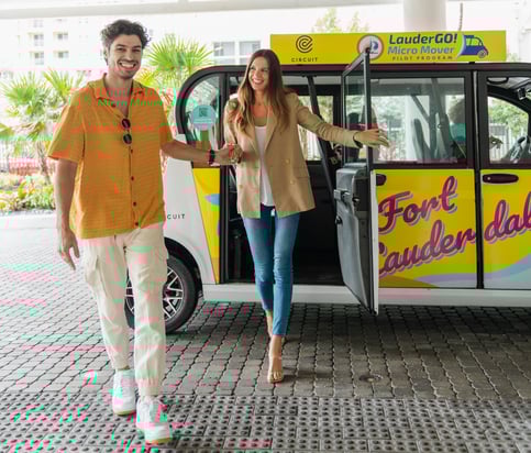 Man and woman smiling exit a Fort Lauderdale Circuit shuttle