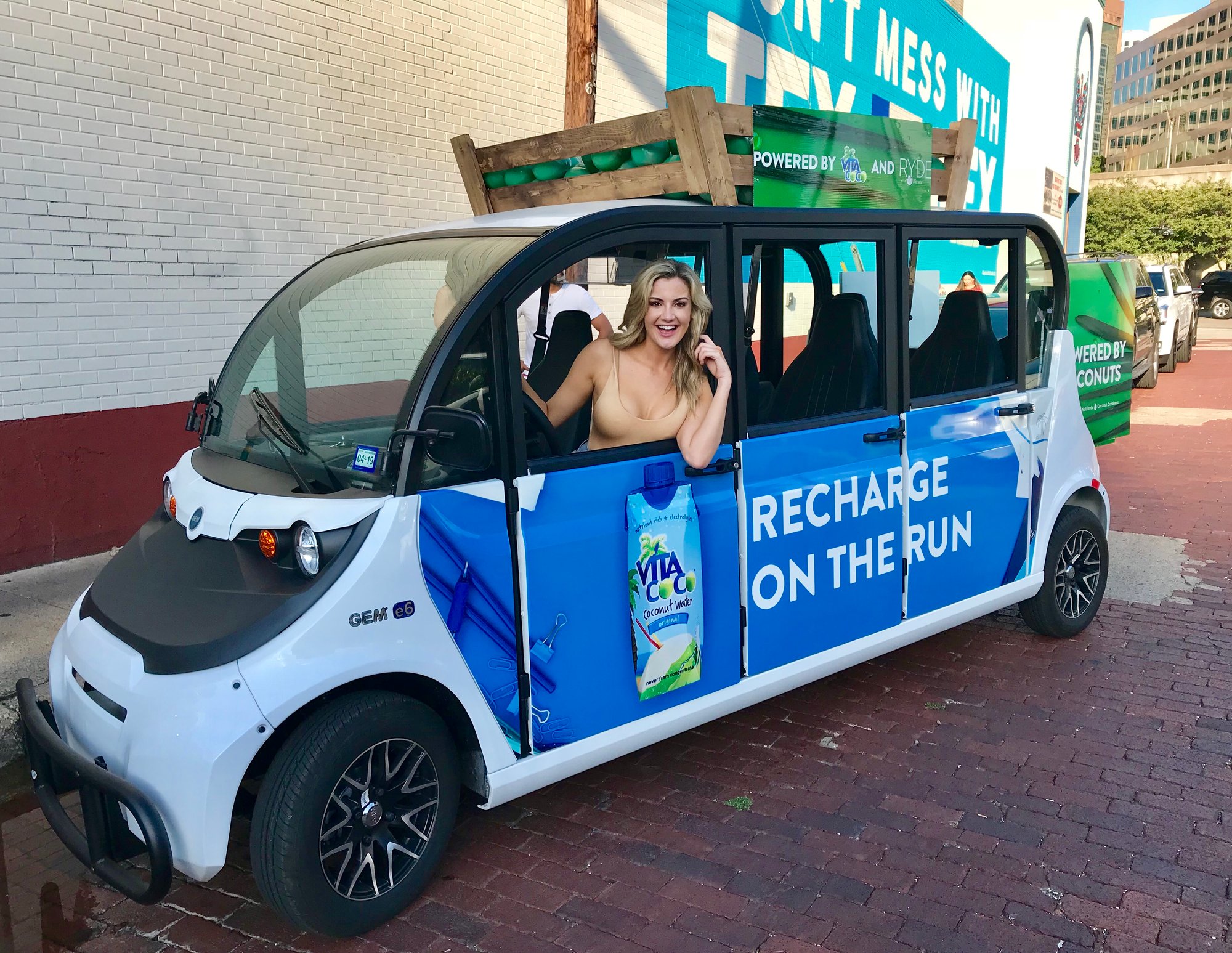 Woman smiling in a Vita Coco branded Circuit car Woman smiling in a Vita Coco branded Circuit car