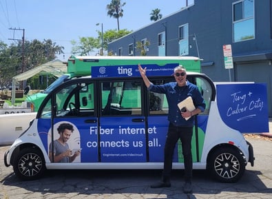 Man waving in front of a Ting internet branded circuit vehicle
