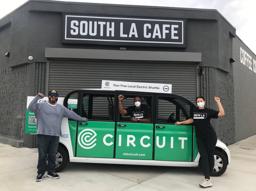 Three people posing with a Circuit car 