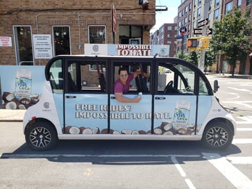 A rider waves from a Vita Coco-branded Circuit vehicle in Williamsburg
