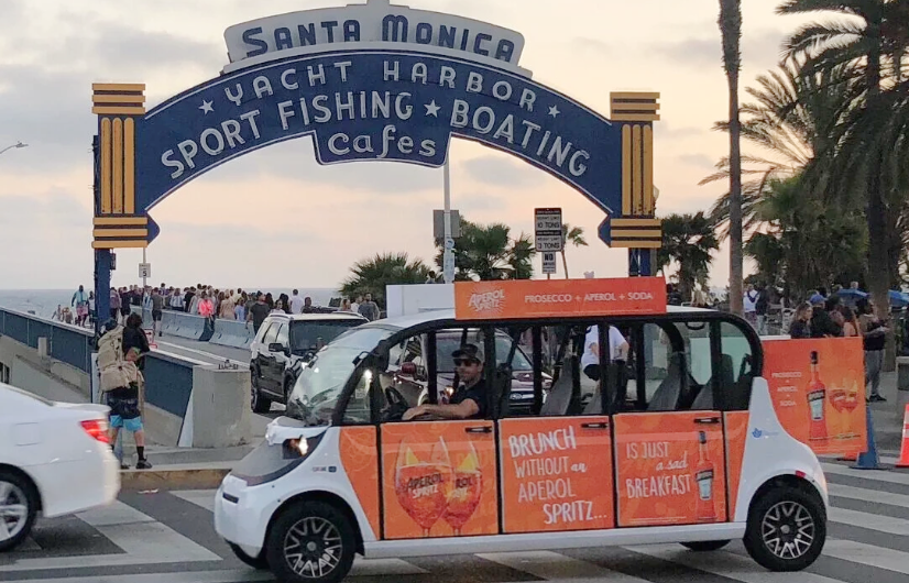 Aperol Spritz branded circuit car in front of the Santa Monica Yacht Harbor