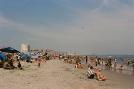 crowds of people lounging on Rockaway Beach in New York